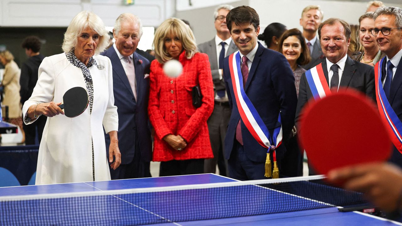 Queen Camilla plays table tennis during a visit to France‍‍`s national stadium and venue for next year‍‍`s Olympic Games.