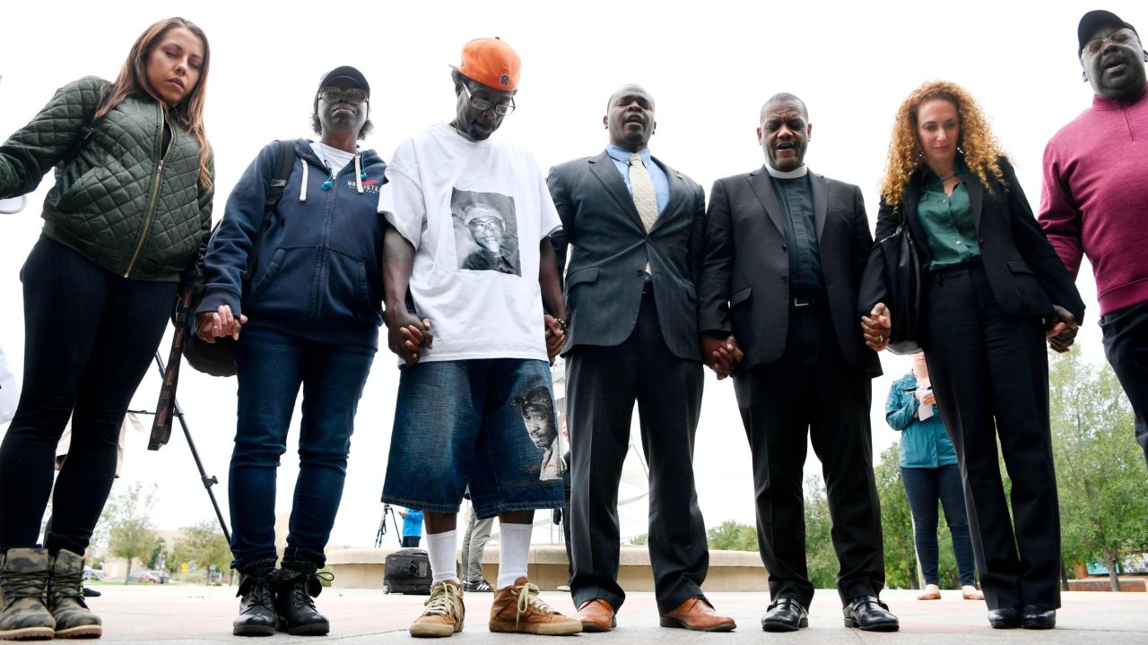 McClain's parents -- Sheneen McClain, second from left, and LaWayne Mosley, third from left-- held hands and prayed with pastors, family, friends and legal counsel after a news conference in Aurora on October 1, 2019. 