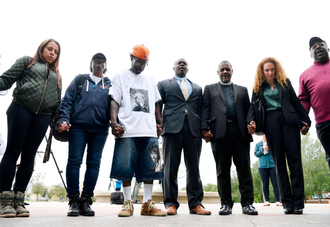 McClain's parents -- Sheneen McClain, second from left, and LaWayne Mosley, third from left-- held hands and prayed with  pastors, family, friends and legal counsel after a news conference in Aurora on October 1, 2019. 