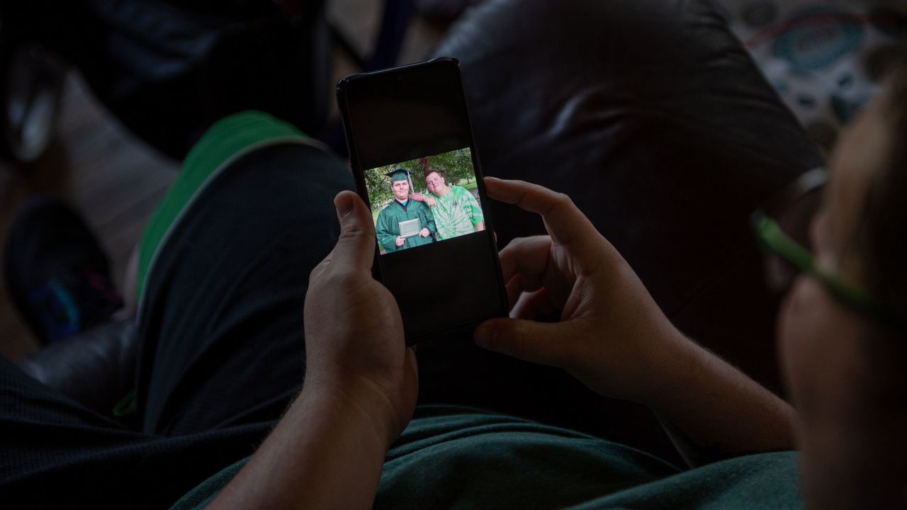 Cody Perkins shows a picture of himself and his younger brother, Quinn, on his phone.