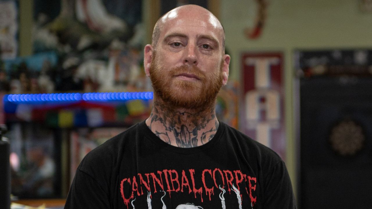 Tattoo artist James Walls poses for a portrait at his shop, Jackson Street Tattoo. After the shooting, he helped raise money for the victims' families.