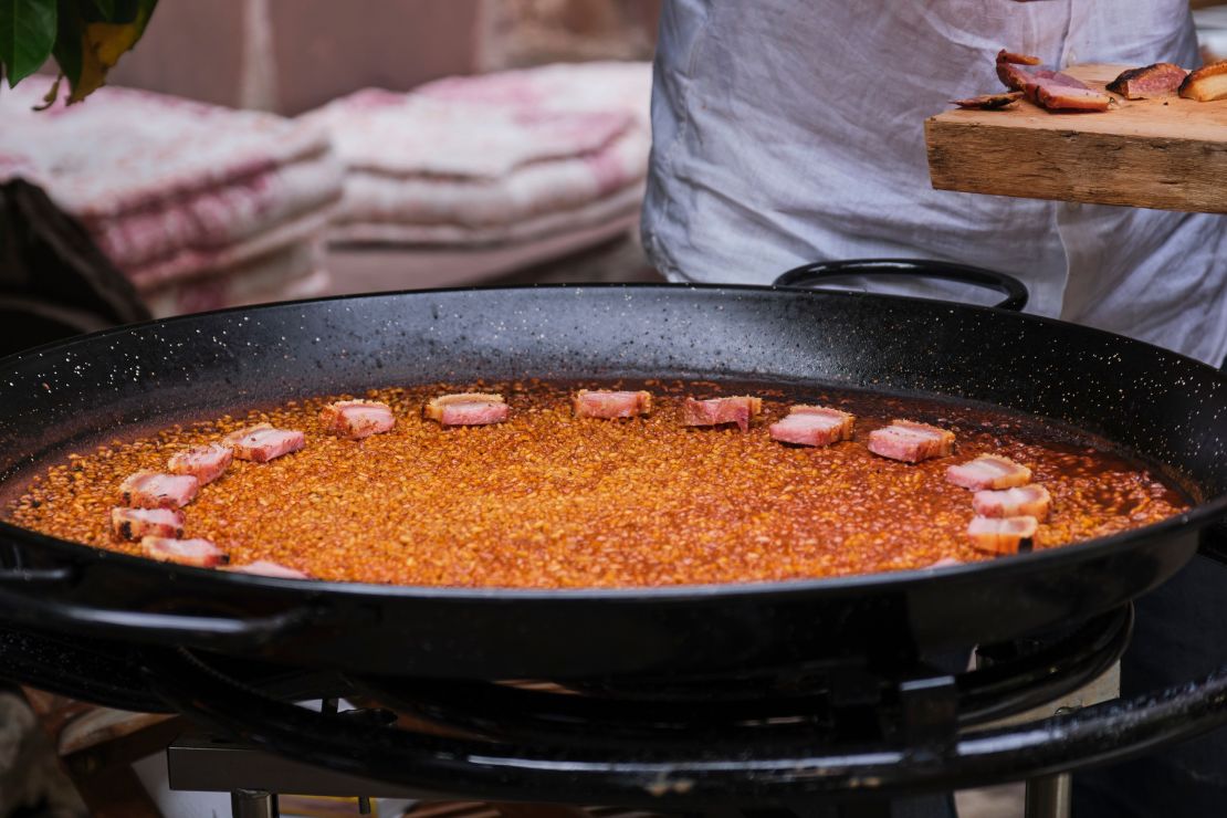 As seen on Discovery +, rice dish made in a paella pan with pork belly