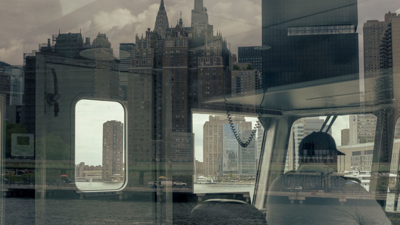 The Manhattan skyline reflected on the East River Ferry near the Queens borough of New York CIty in August 2022.