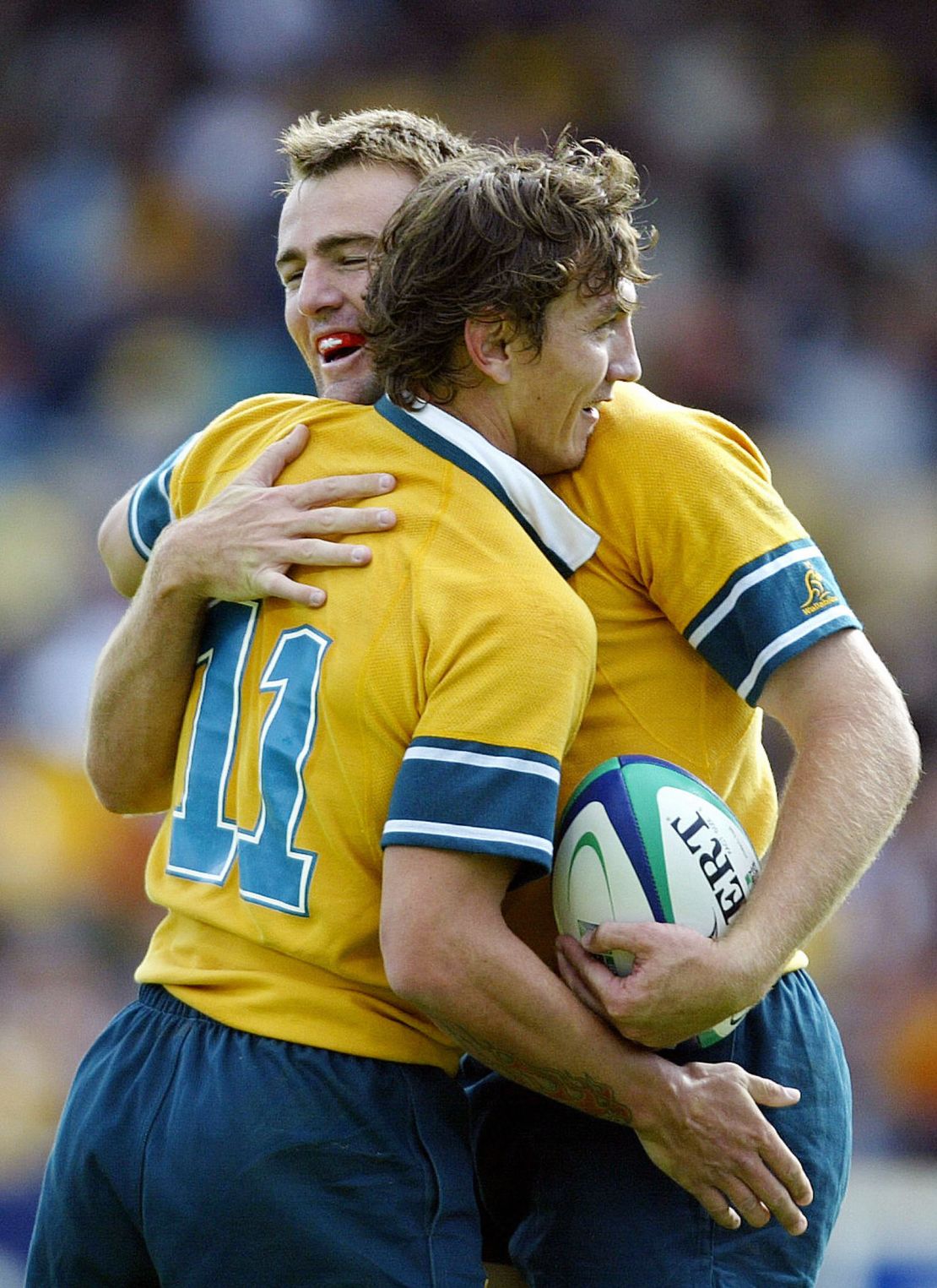ADELAIDE, AUSTRALIA:  Australian fullback Chris Latham (L) is congratuled by his teammate wing Mat Rogers during the Rugby World Cup Pool A match between Australia and Namibia at Adelaide oval in Adelaide, 25 october 2003. Australia beat Namibia 142-0.  AFP PHOTO/ Christophe SIMON  (Photo credit should read CHRISTOPHE SIMON/AFP via Getty Images)