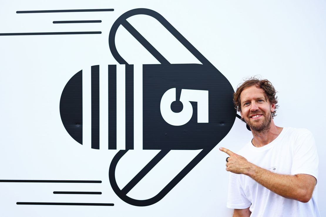 SUZUKA, JAPAN - SEPTEMBER 21: Sebastian Vettel poses for a photo with the Buzzin' Corner logo during previews ahead of the F1 Grand Prix of Japan at Suzuka International Racing Course on September 21, 2023 in Suzuka, Japan. (Photo by Mark Thompson/Getty Images)