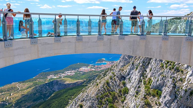 Biokovo, Croatia - july, 11.2022: Tourist walking and looking on the skywalk Biokovo. In distance Adriatic sea and town of Makarska, Croatia