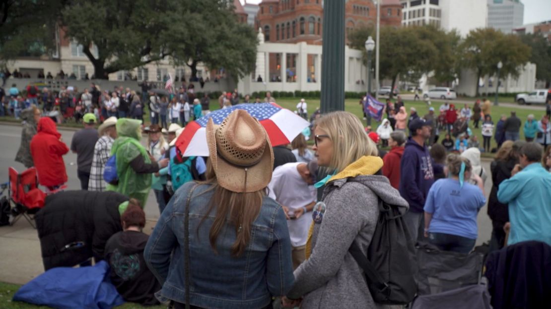 A crowd gather on the grassy knoll in Dallas in November 2021 