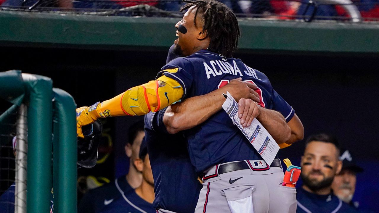 Atlanta Braves' Ronald Acuña Jr. gets a hug from the team's manager, Brian Snitker, after hitting a solo home run during a game against the Washington Nationals on Friday, Sept. 22. 