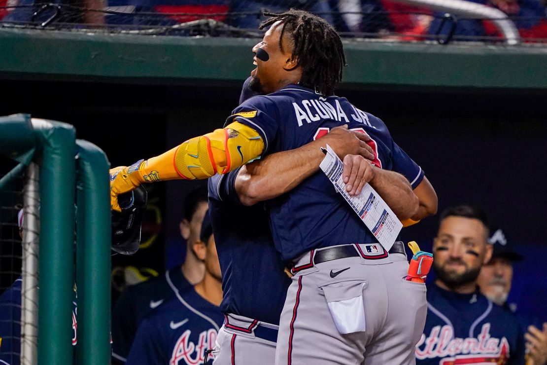 Atlanta Braves' Ronald Acuña Jr. gets a hug from the team's manager, Brian Snitker, after hitting a solo home run during a game against the Washington Nationals on Friday, Sept. 22. 