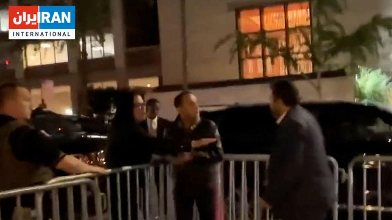 A frame taken from Iran International's video shows part of the encounter between the Iranian official, right, and journalist Kian Amani, center.