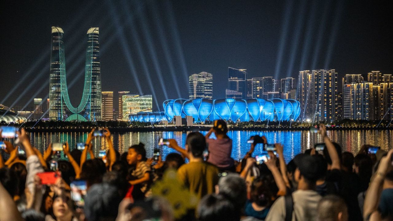 People gather at the promenade of Qiantang River to watch the light show of the Hangzhou Olympic Sports Centre Stadium ahead of the 2022 Asian Games in Hangzhou, China on September 19, 2023. 