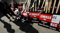 WGA members turn in their signs at the end of their first day of their strike in front of Paramount Studios in Hollywood on May 2, 2023. The union were unable to reach a last minute-accord with the major studios on a new three-year contract to replace one that expired Monday night. 