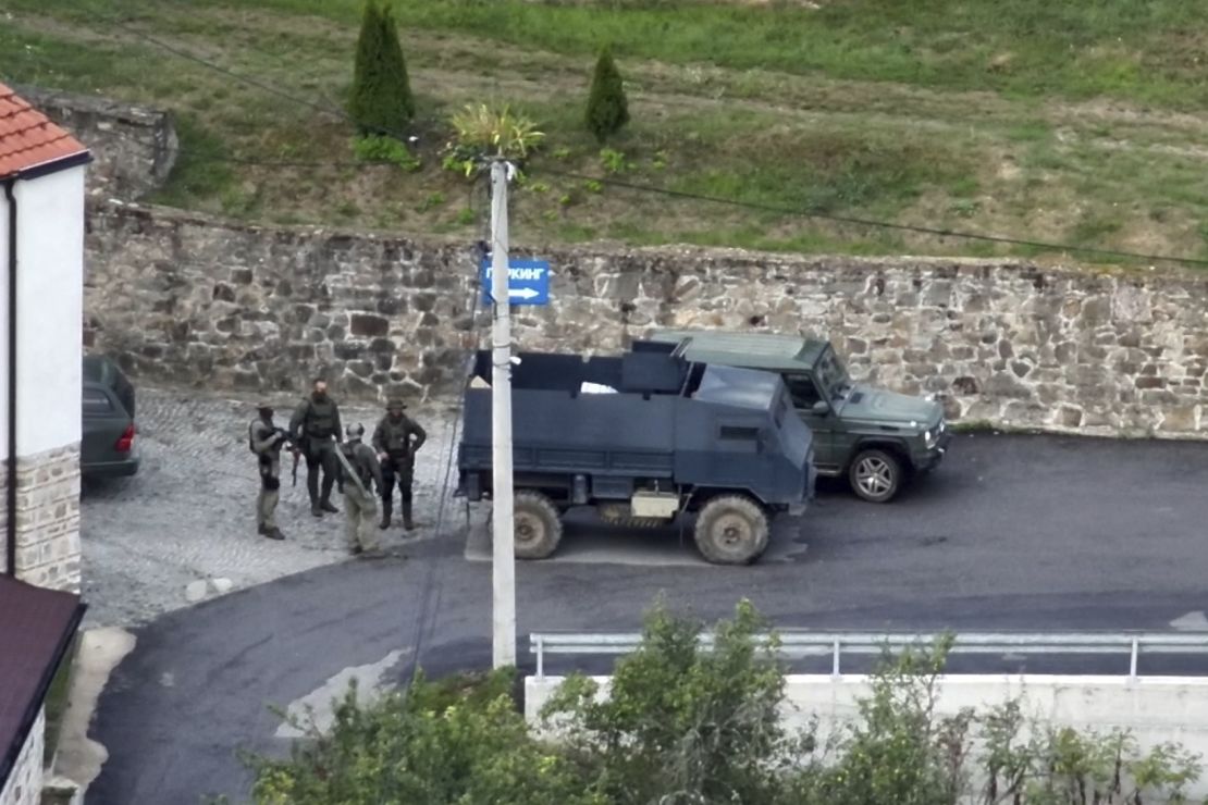 Kosovo Police and a group of armed, masked men stand in front of the Banjska Monastery in North Kosovo.