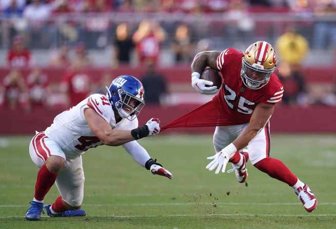 San Francisco 49ers running back Elijah Mitchell is tackled by New York Giants linebacker Micah McFadden in the second quarter at Levi's Stadium on September 24. The 49ers remain undefeated after their 30-12 Thursday Night Football win on September 21.
