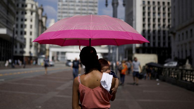 Anelise de Jesus holds her 2-month-old son Joao, as they shelter under an umbrella from the sun, during a heatwave in the centre of Sao Paulo, Brazil September 22, 2023. REUTERS/Amanda Perobelli     TPX IMAGES OF THE DAY