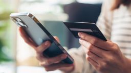 Woman hand holding credit cards and using smartphone for shopping online.