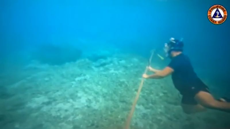 South China Sea: Filipino diver removes floating barrier put in by China