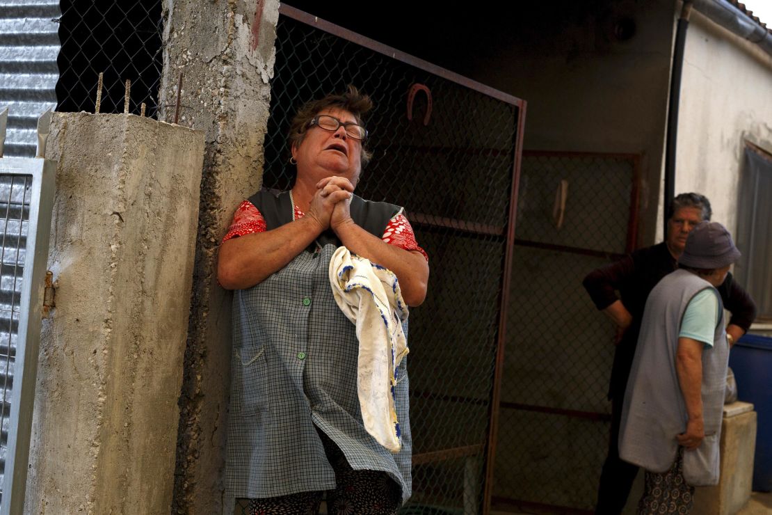 A woman reacts to flames approaching her house after a wildfire took dozens of lives on June 19, 2017 in a village near Pedrogao Grande, in Leiria district, Portugal.