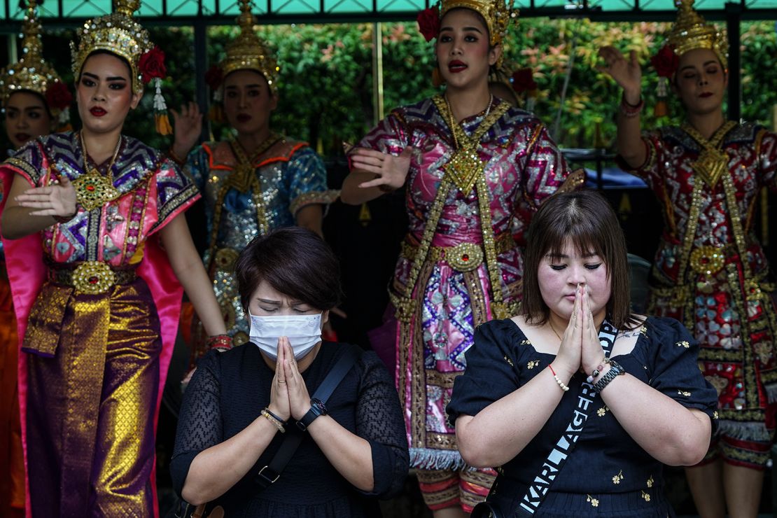 Chinese tourists pray in front of Thai dancers  at the Erawan Shrine in Bangkok, Thailand on September 22, 2023. 