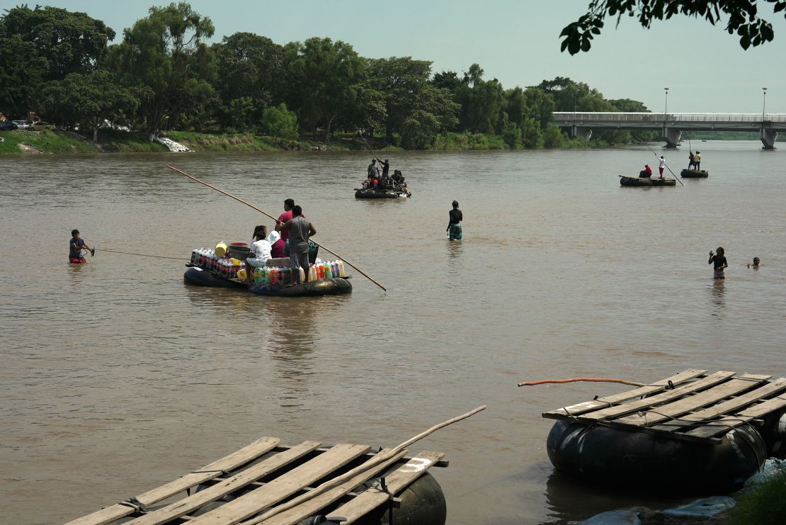 Migrants cross the Suchiate River between Guatemala and Mexico on makeshift rafts.