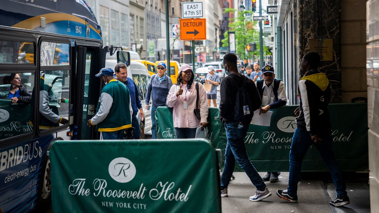 Migrants are seen boarding a bus at the Roosevelt Hotel on May 21, 2023, soon after the hotel became an intake center.