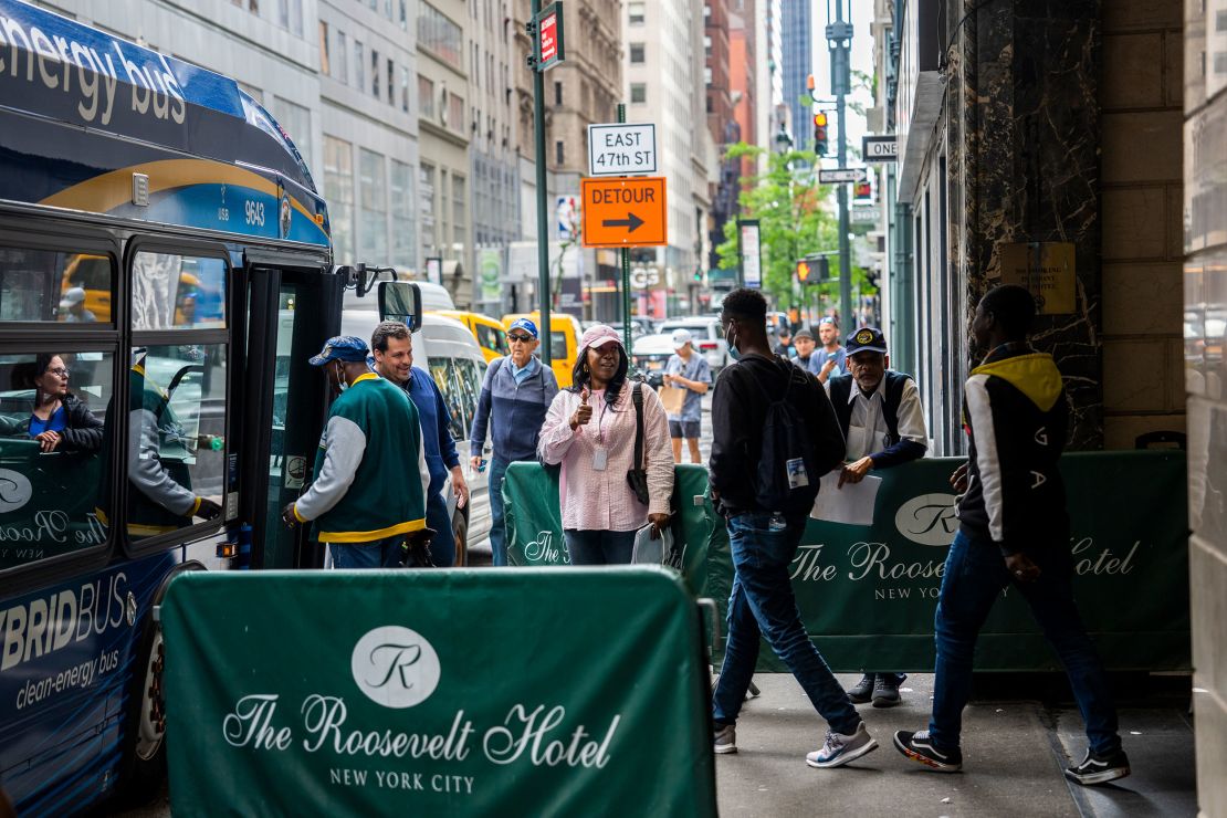 Migrants are seen boarding a bus at the Roosevelt Hotel on May 21, 2023, soon after the hotel became an intake center.