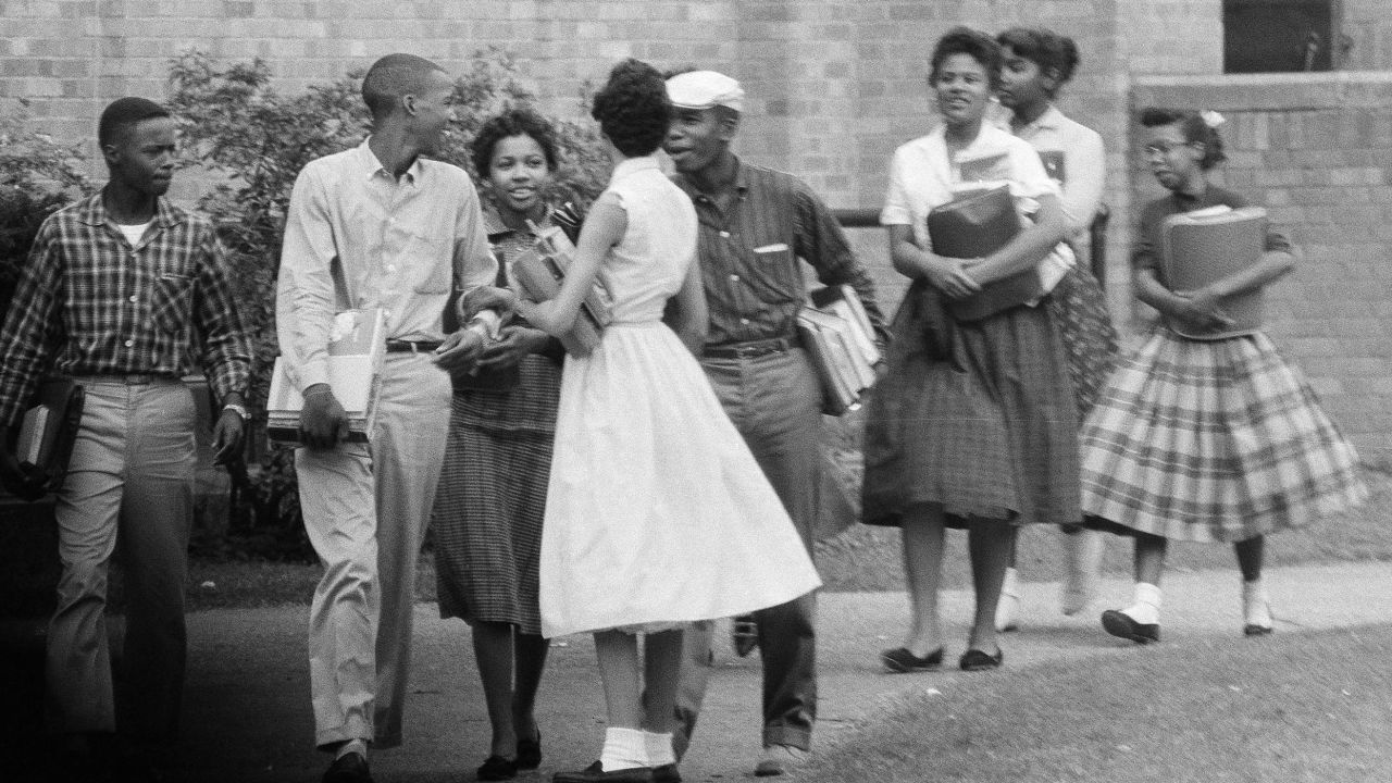 The first Black students to enroll at Central High School in Little Rock, Ark., leave the building and walk toward a waiting Army station wagon following their classes on Oct. 2, 1957. 