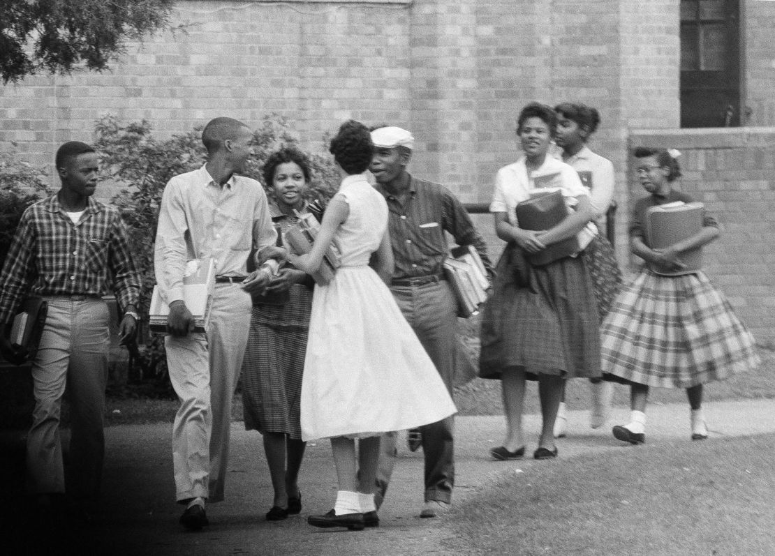 The first Black students to enroll at Central High School in Little Rock, Ark., leave the building and walk toward a waiting Army station wagon following their classes on Oct. 2, 1957.