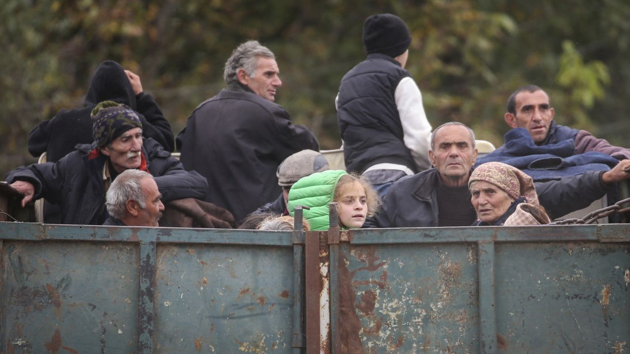 Refugees ride in the back of a truck as they arrive in Kornidzor, Armenia, September 26, 2023.