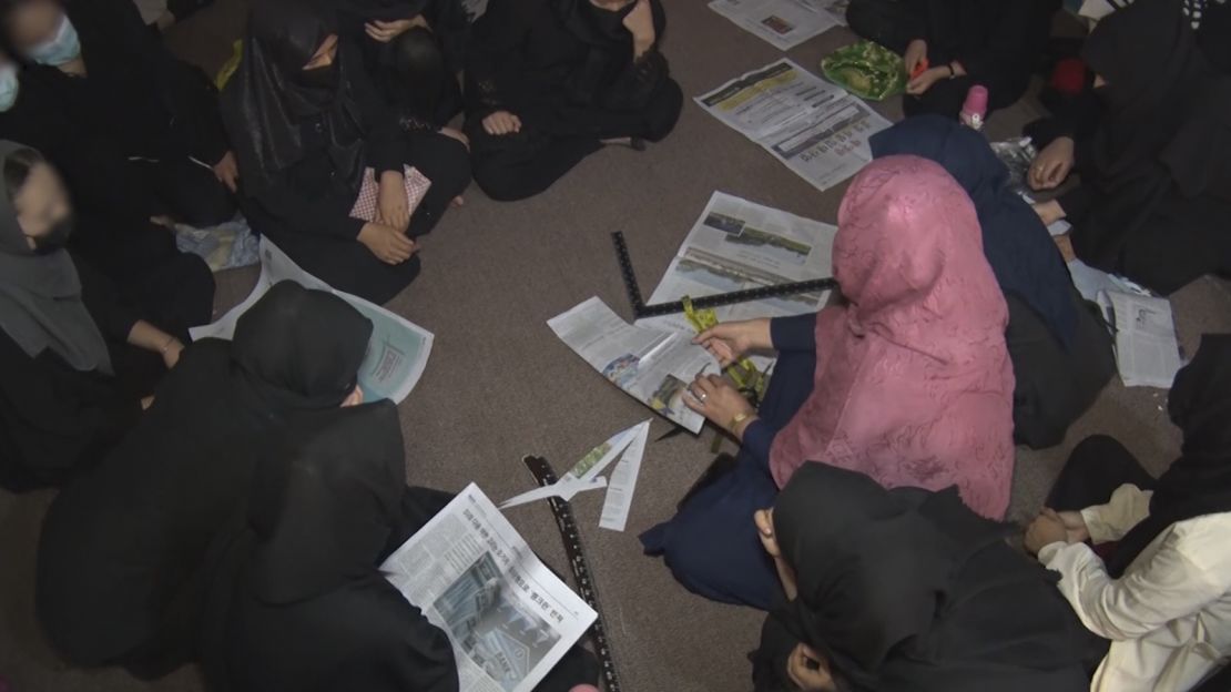 Girls are taught tailoring techniques using newspapers at the hidden school in Afghanistan.