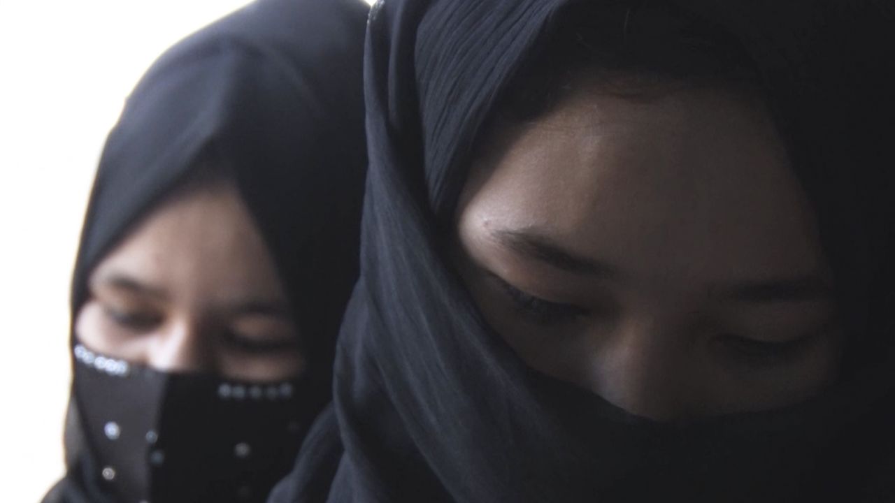 Des filles, le visage partiellement couvert, suivent des cours dans une école cachée en Afghanistan.