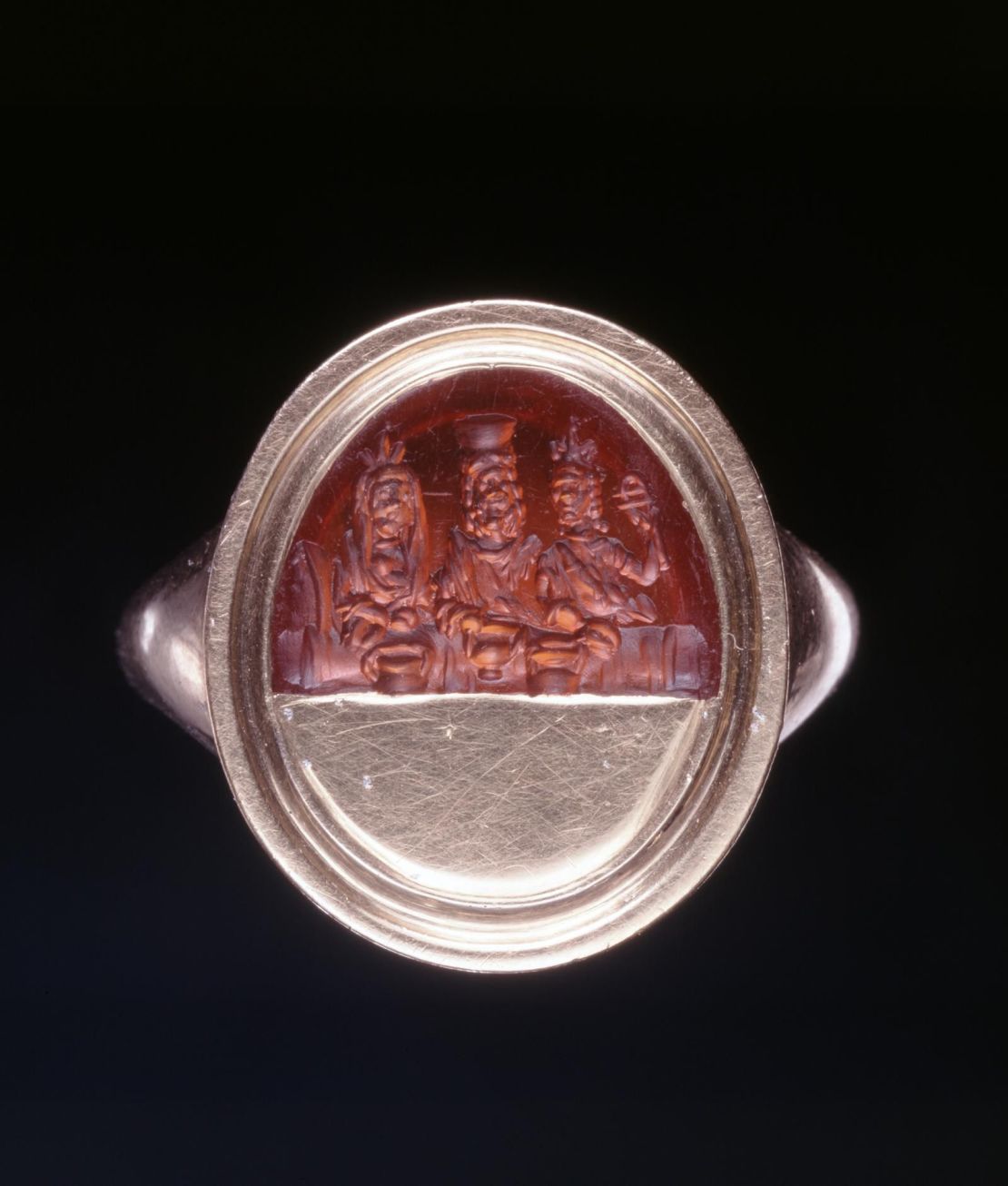 Roman sard intaglio, engraved with the divine couple Serapis and Isis, and a female figure holding a sistrum. 1st-3rd century AD.