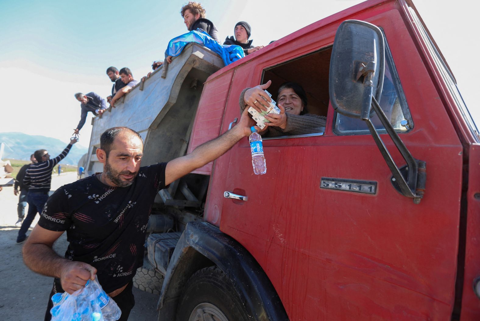 David Harapetyan, an ethnic Armenian and taxi driver who came to Kornidzor from Russia to provide assistance, hands food and water to people from Nagorno-Karabakh on September 27.