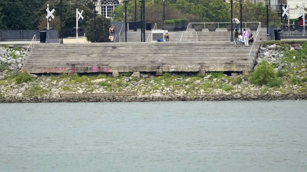 The low water level of the Mississippi River is seen as people sit on steps that normally meet the river in the French Quarter of New Orleans on Sept. 25, 2023. 