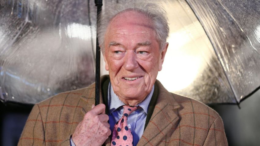 British actor Michael Gambon shelters from the rain as he arrives for the world premiere of the film Dad's Army in London on January 26, 2016. (Photo by JUSTIN TALLIS / AFP) (Photo by JUSTIN TALLIS/AFP via Getty Images)