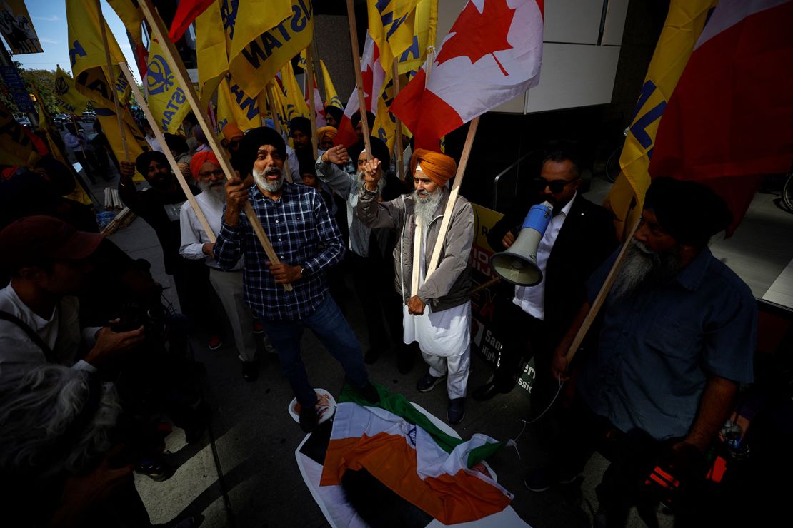 People stomp on an Indian flag and a cutout of Indian prime minister Narendra Modi during a Sikh rally outside the Indian consulate in Toronto to raise awareness for the Indian government's alleged involvement in the killing of Sikh separatist Hardeep Singh Nijjar in British Columbia on September 25, 2023.