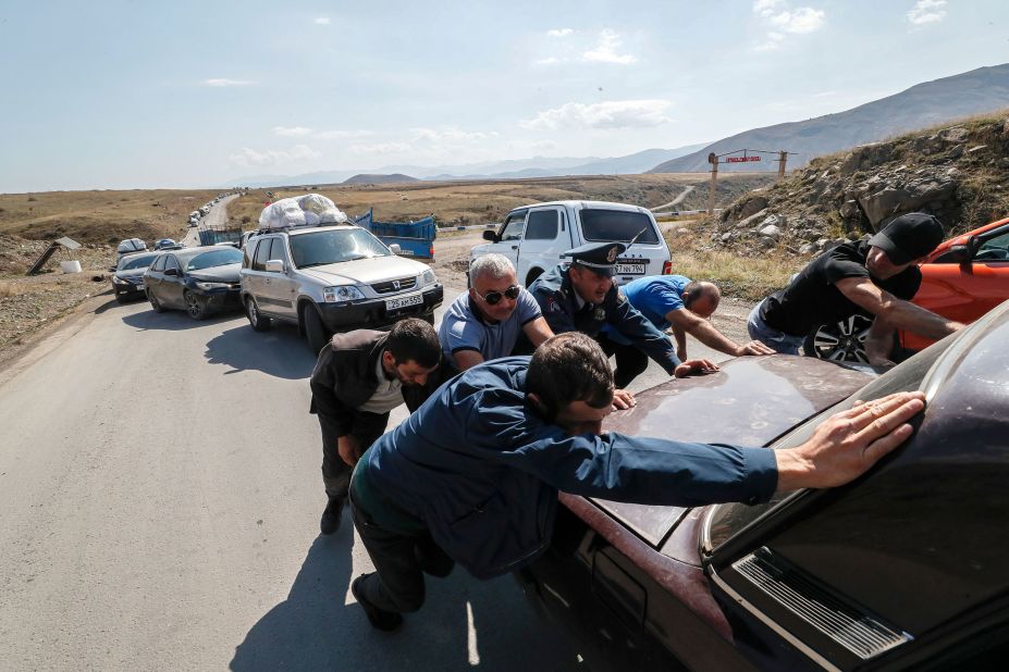 People help move a broken-down car near Kornidzor on September 28. 