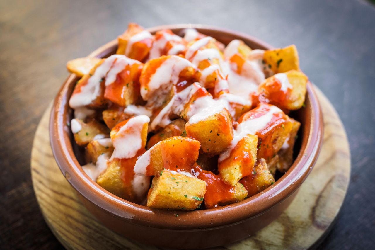 Crispy patatas bravas are served with a spicy sauce.
