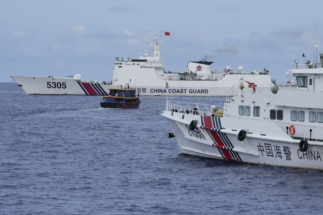 A Philippine supply boat, center, maneuvers around Chinese coast guard ships as they tried to block its way near Second Thomas Shoal, locally known as Ayungin Shoal, at the disputed South China Sea on August 22.