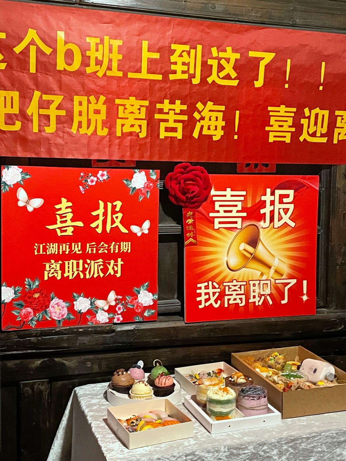 Cakes and pastries at Liang's resignation party. The sign reads: 'I quit!'
