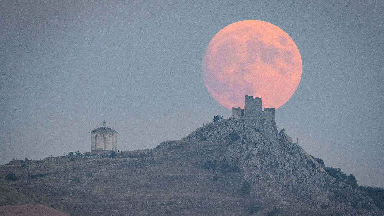Pilnas Derliaus mėnulis matomas kylant už Rocca Calassio pilies ir Santa Maria della Pietà bažnyčios Calassio mieste (L'Aquila, Abruzzo), Italijoje, 2023 m. rugsėjo 28 d. Derliaus mėnulis yra pilnatis, kuri būna arčiausiai rudens lygiadienis.  Tai supermėnulis, o tai reiškia, kad jis atrodys didesnis ir šviesesnis nei įprastai, o 2023 m. bus dar vienas supermėnulis. (Nuotrauka Lorenzo Di Cola/Noor Photo per Getty Images)