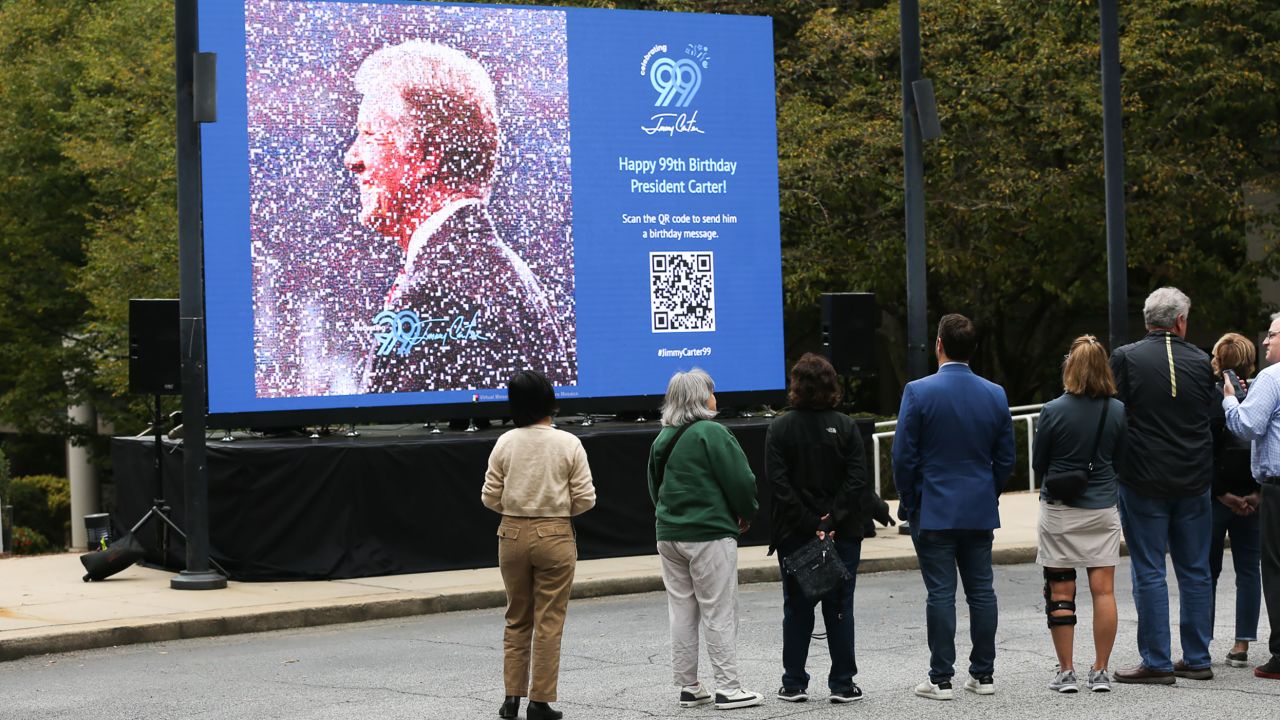 Jimmy Carter's grandson Jason Carter, center, looks Thursday at a digital mosaic of his grandfather at The Carter Center.