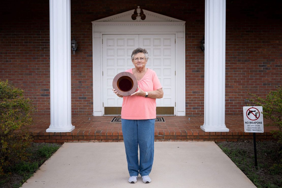 Jan Williams, who attends church with former President Jimmy Carter and taught his daughter fourth grade, poses in front of Maranatha Baptist Church in Plains with a collection plate Carter made.