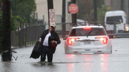 A man carries his belongings as he abandons his vehicle which stalled in floodwaters during a heavy rain storm in the New York City suburb of Mamaroneck in Westchester County, New York, U.S., September 29, 2023. REUTERS/Mike Segar