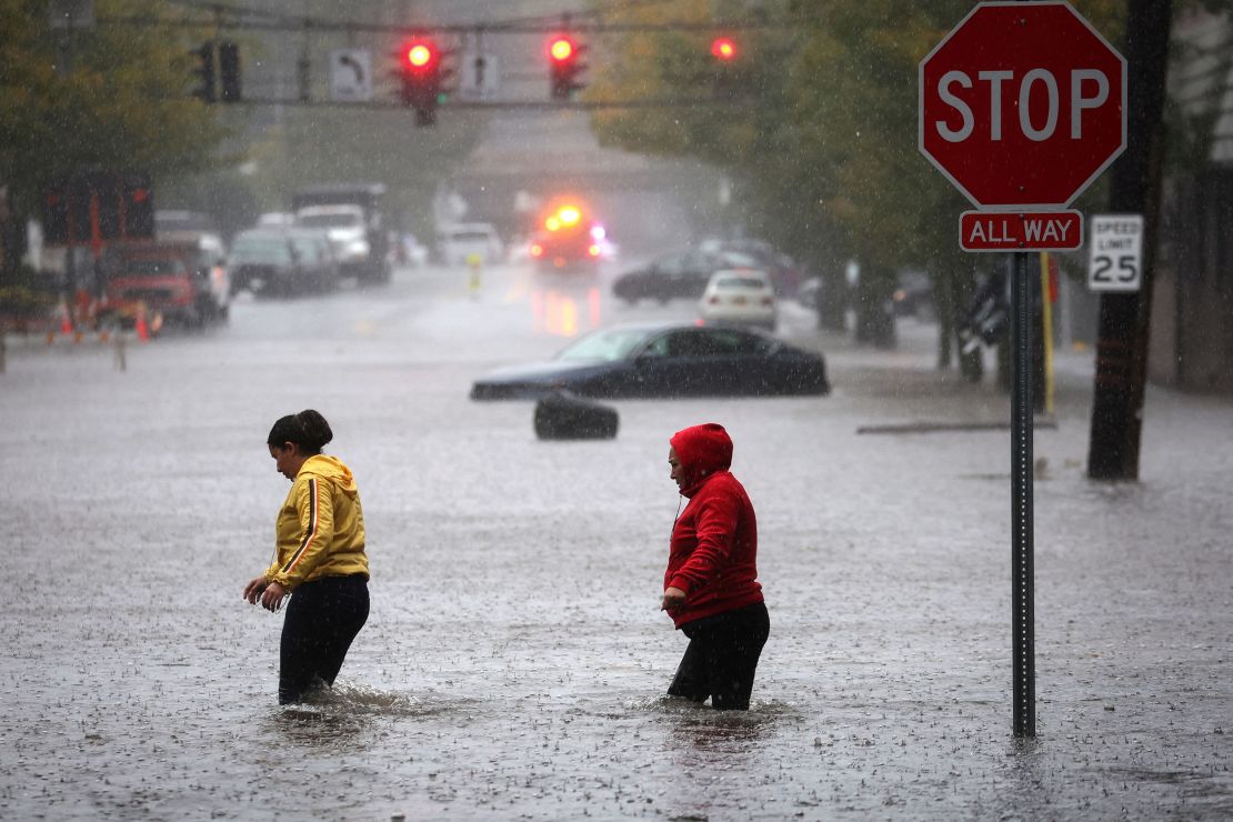 Residents walk through floodwaters in the New York City suburb of Mamaroneck in Westchester County, New York, on Friday.