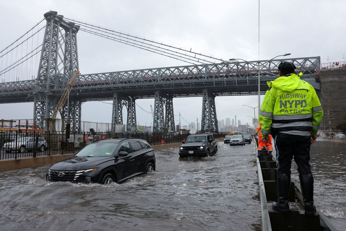 A police officer from the NYPD Highway Patrol oversees a flooded street on Friday.