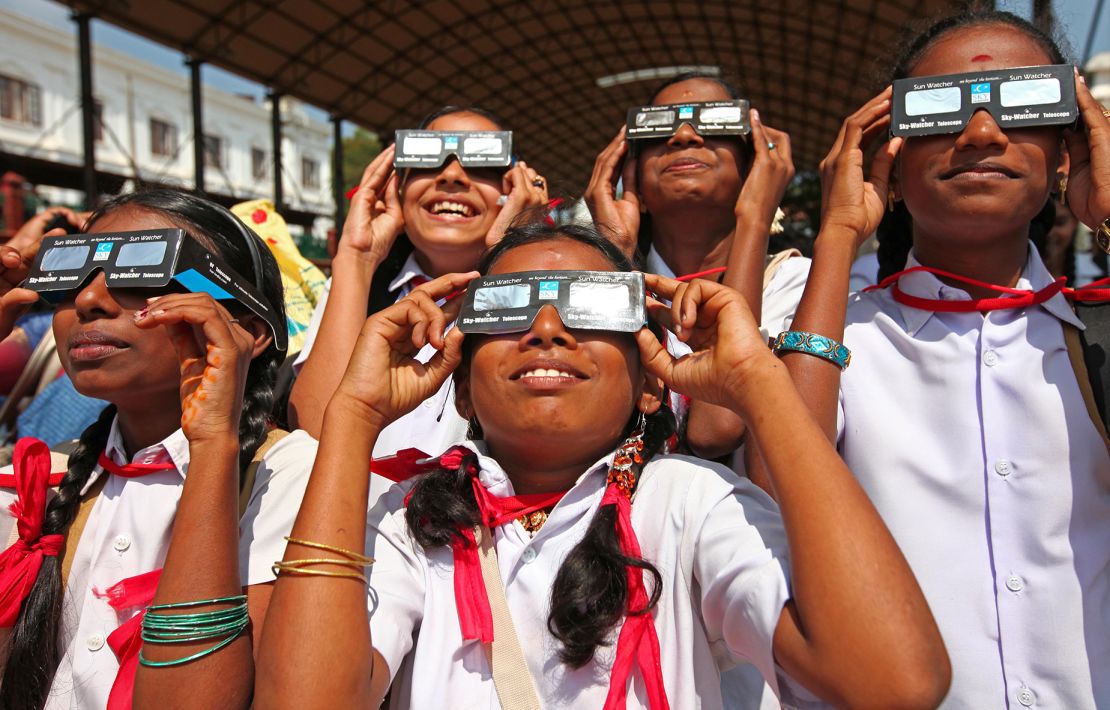 TRIVANDRUM, INDIA - JANUARY 15: Indian people observe the rare Annular Solar Eclipse at the central stadium on January 15, 2010 in Thiruvananthapuram (Trivandrum), Kerala, South India.This rare astronomical event lasts for 7 minutes 15 seconds. During the annular eclipse, the moon passes directly in front of the sun, leaving a spectacular ring of fire. (Photo by EyesWideOpen/Getty Images)