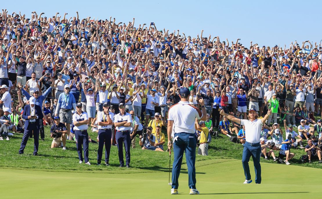 Tommy Fleetwood of The European Team salutes his partner Rory McIlroy after Rory had holed a putt to win their match by 2&1 on the 17th green against Justin Thomas and Jordan Spieth during the Saturday morning foursomes matches of the 2023 Ryder Cup at Marco Simone Golf Club on September 30, 2023 in Rome, Italy.
