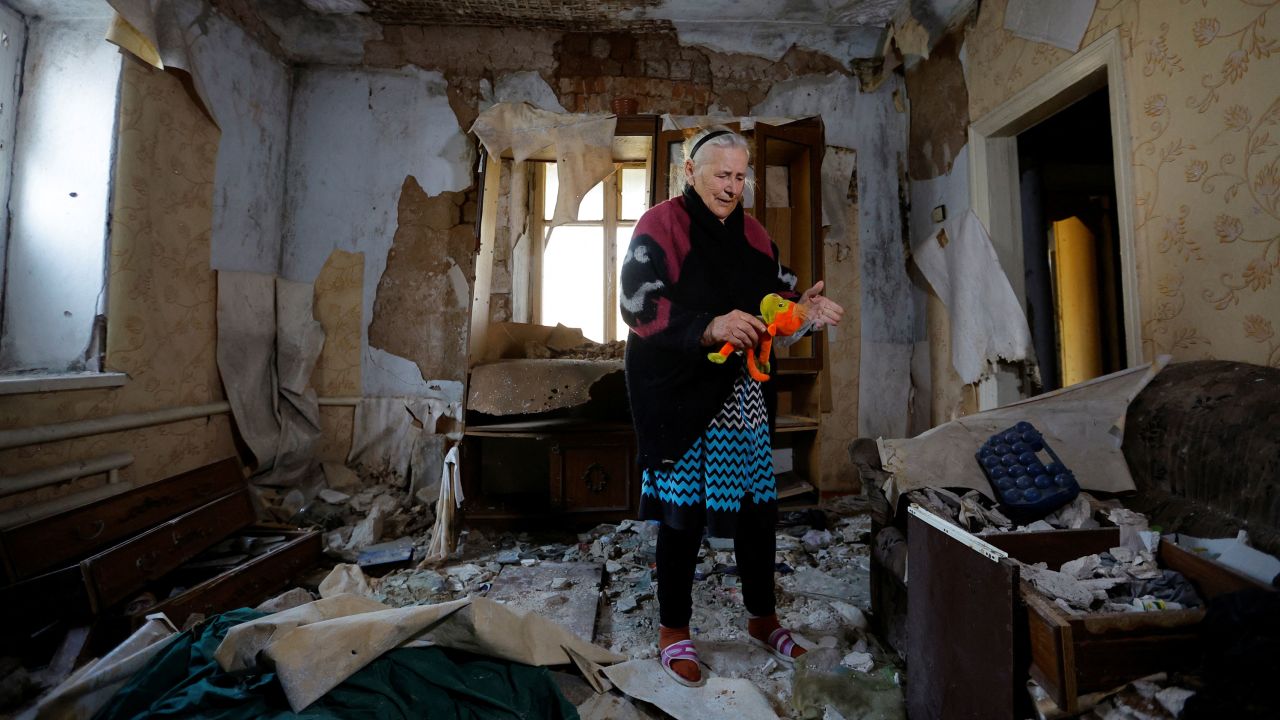An 85-year-old resident stands inside her destroyed house in the Russian-controlled Ukrainian city of Mariupol on Tuesday.