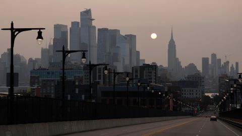Wildfire smoke drifting back into the Northeast shrouds the sun as it rises behind the Empire State Building in New York City on October 1, 2023, as seen from Hoboken, New Jersey.  